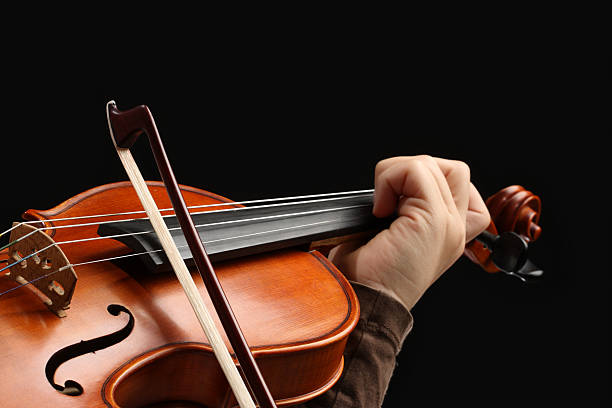 violinist playing on violin isolated before black background